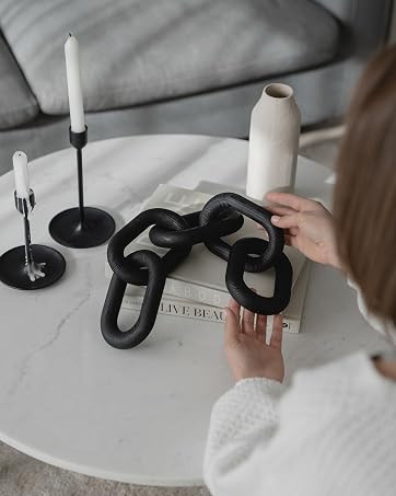 Woman placing Peakoly black wood chain on marble coffee table