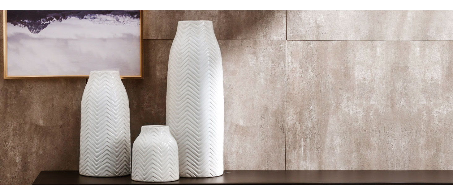 Three-piece corrugated white porcelain vases on a black table in front of the wall
