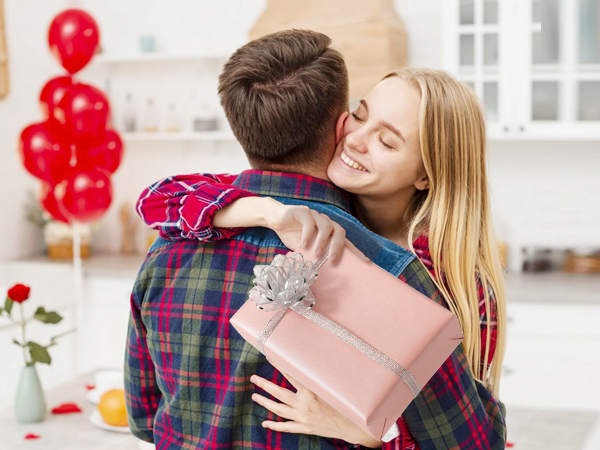 a man hugs a woman with a gift