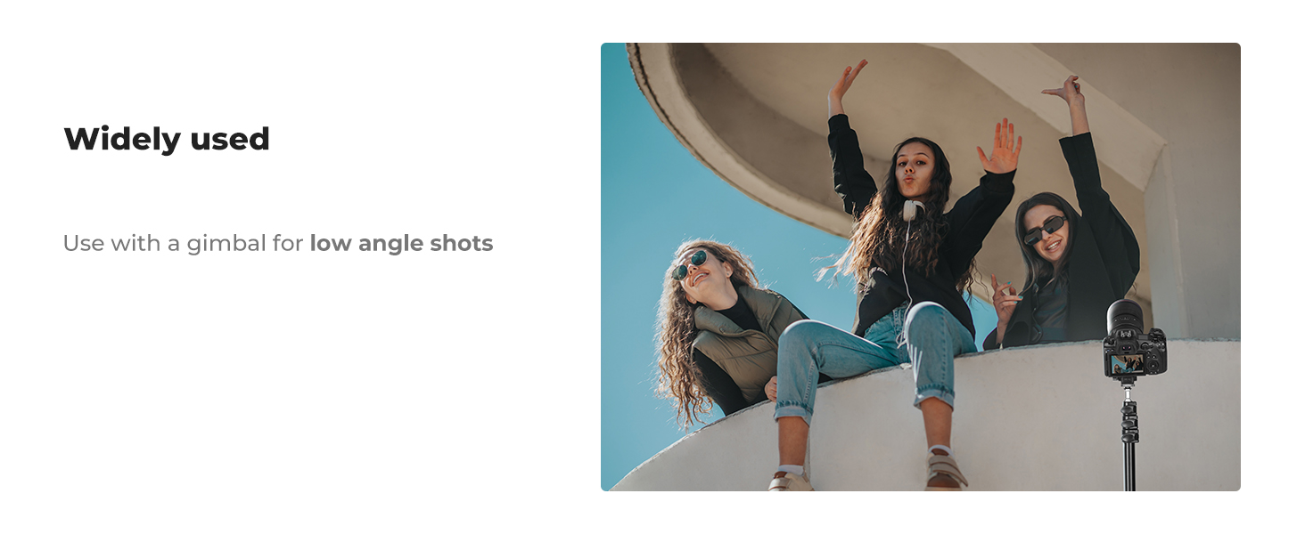 Camera gimbal mounted on tripod for low-angle shots. Three people sitting on ledge above, with arms raised, demonstrating wide-angle capture capability.