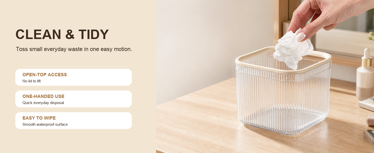 Hand placing a tissue into a clear open-top mini desktop trash can