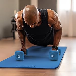 man doing push up with TONE fitness 10 pound dumbbells and yoga mat at home