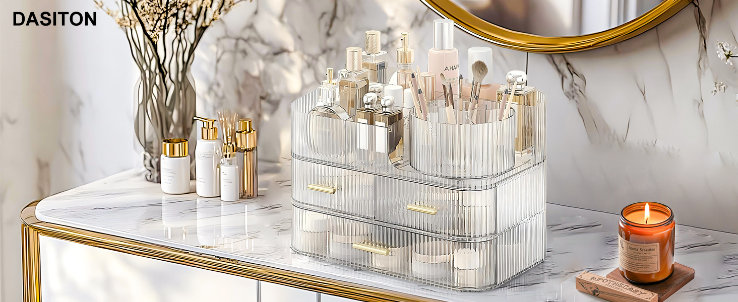 Clear acrylic makeup brush holder with gold accents. Two-tier design with multiple compartments for organizing various sizes of brushes. Displayed on marble surface with decorative elements.