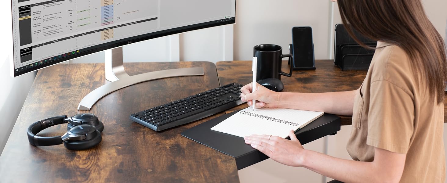 Woman writing on desktop surface