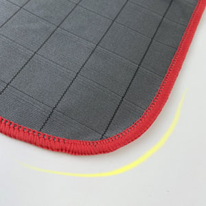 a close up of a sewing machine with a red and grey fabric