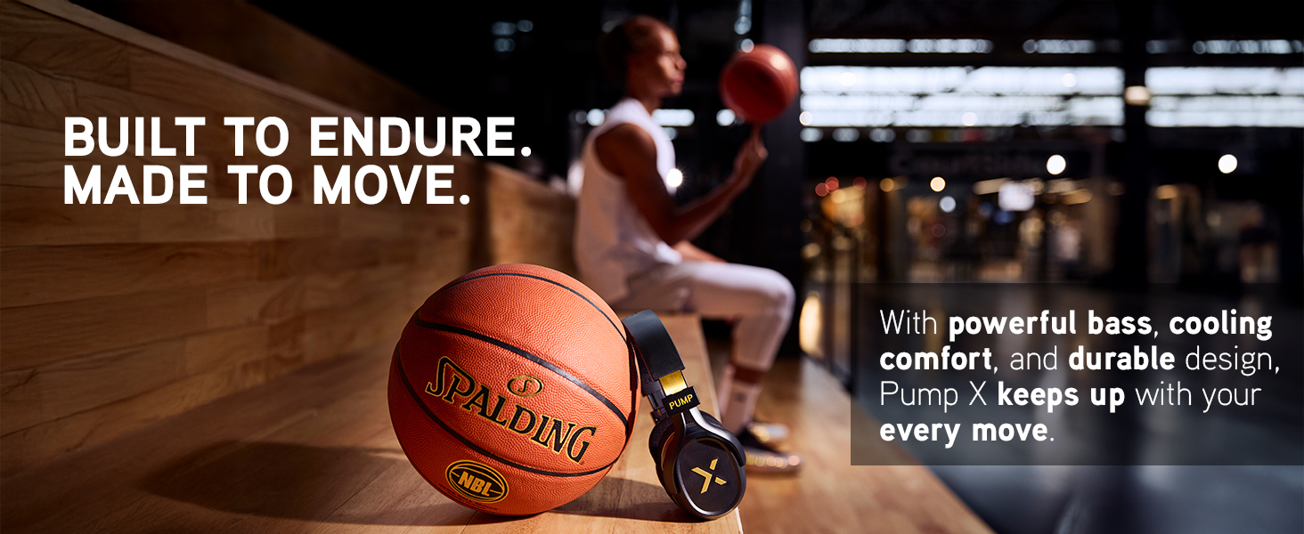 Black PumpX headphones rest beside a basketball on a court bench, athlete blurred in background