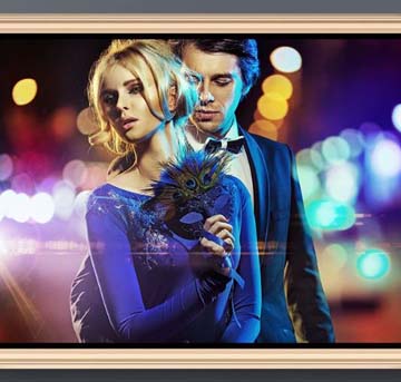 A man in woman in fancy attire in front of blurred out city lights