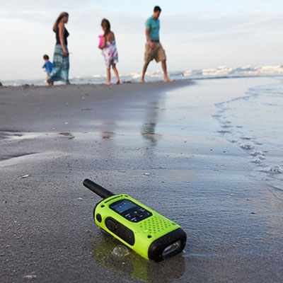 A T600 on a soaked beach, in front of a family of four playing near waters   