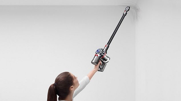 a woman using Dyson V7 Absolute to clean the ceiling