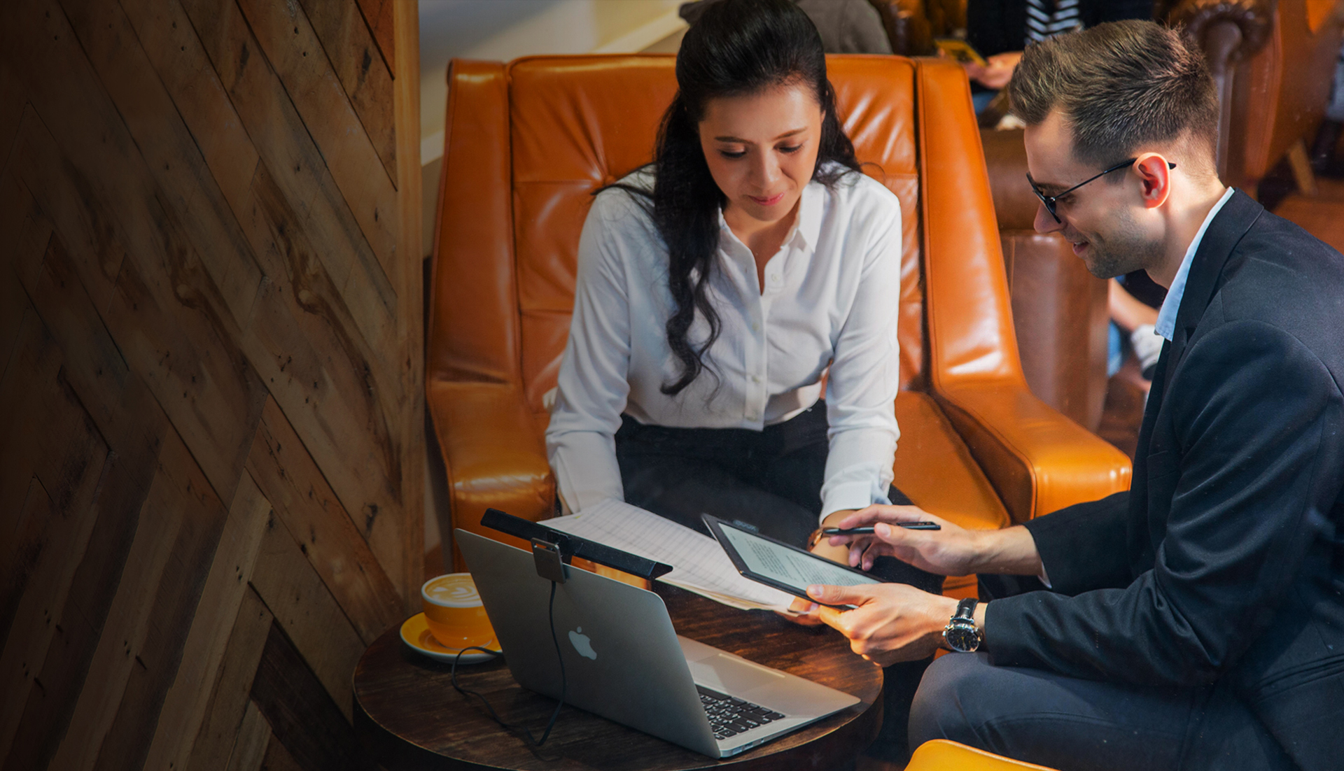 BenQ ScreenBar Lite mounted on an open macbook facing towards two office workers going over notes on paper and a tablet