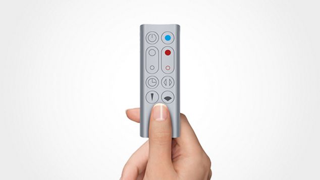 a hand holding the remote for Dyson AM09 Fan Heater