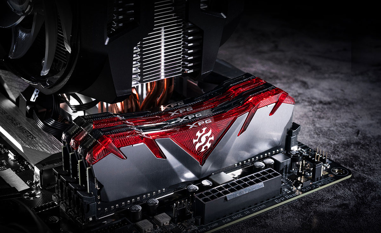 Two pairs of memory modules with one pair having transparent red top cover and the other pair having transparent black top cover are installed on a motherboard next to a high CPU cooler.