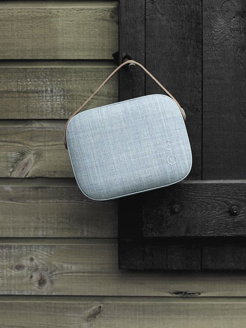 Gray Helsinki Speaker Hanging from a stud on a window sill next to wood panels