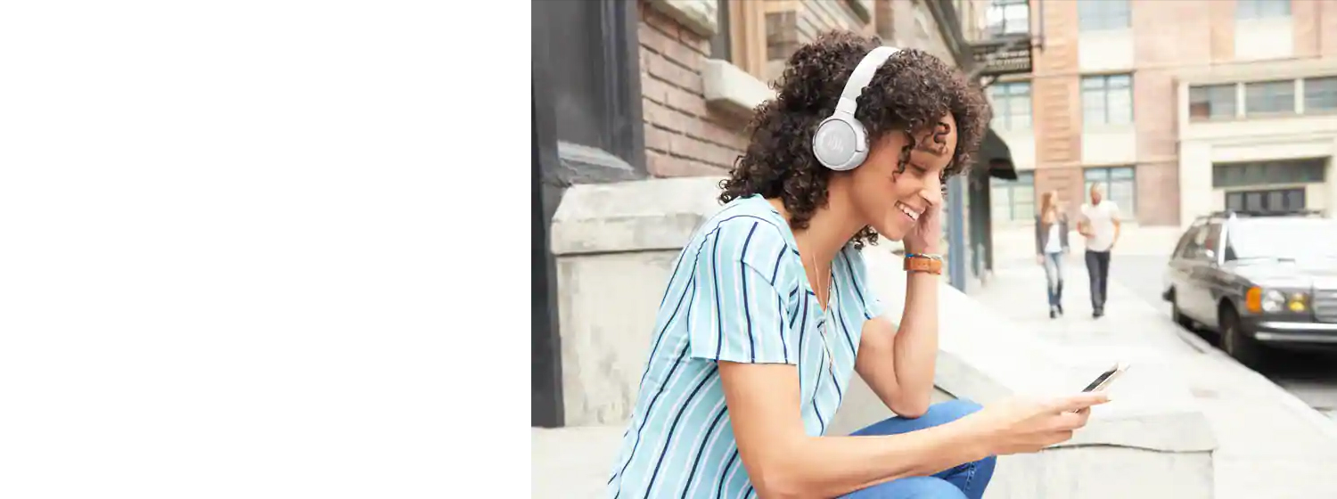 A gir wearing JBL T600BTNC Wireless On-Ear Active Noise-Cancelling Headphones enjoying music