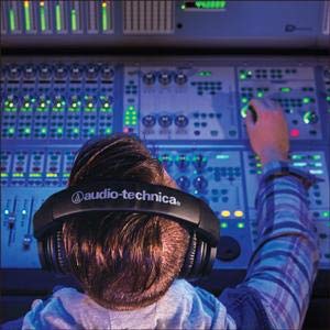 An Overhead Shot of a Studio Engineer at a Mixing Console, Wearing Audio-Technica Monitor Headphones