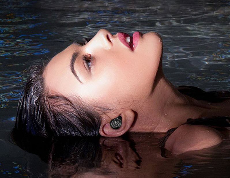 a woman in swimming pool wearing True Wireless Earbuds