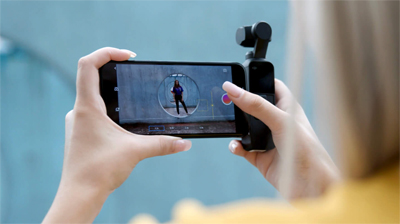 Osmo Pocket connected to a phone in a woman's hands as she prepares to capture