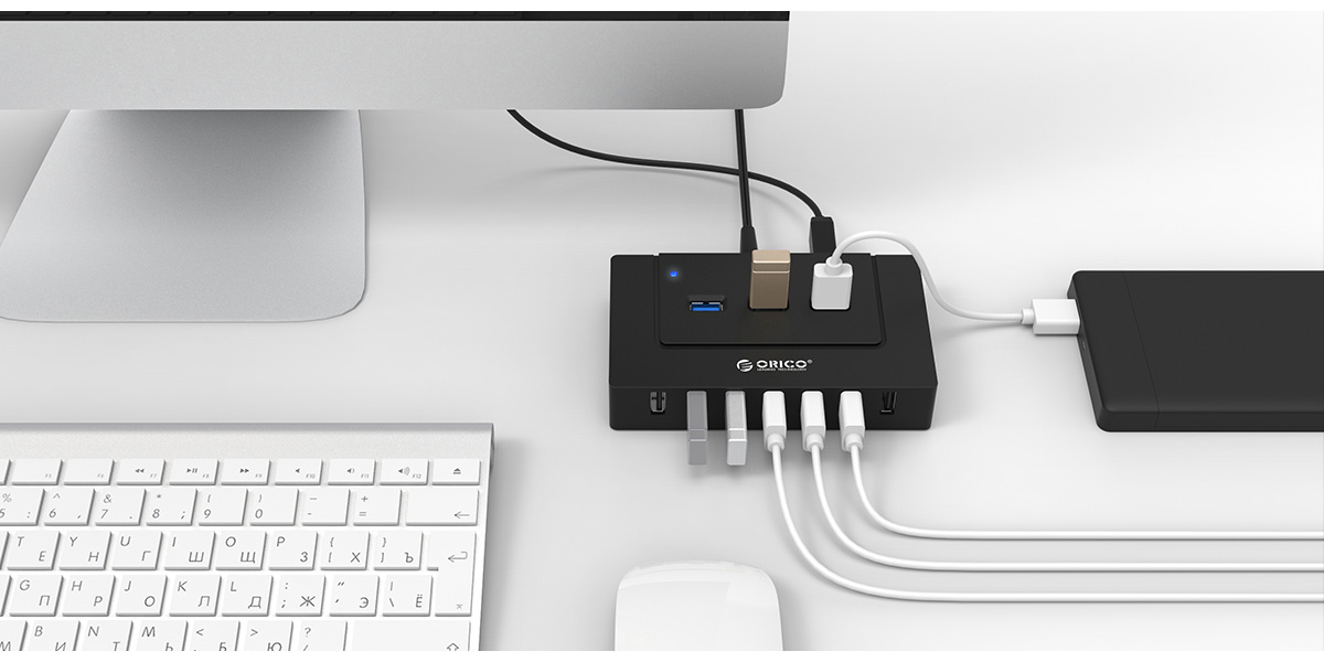 Orico USB Hub Next to a Desktop All-in-One PC, Keyboard, Mouse and USB devices + cables plugged in