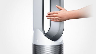 A man puts his hand in the air outlet of the purifier fan   