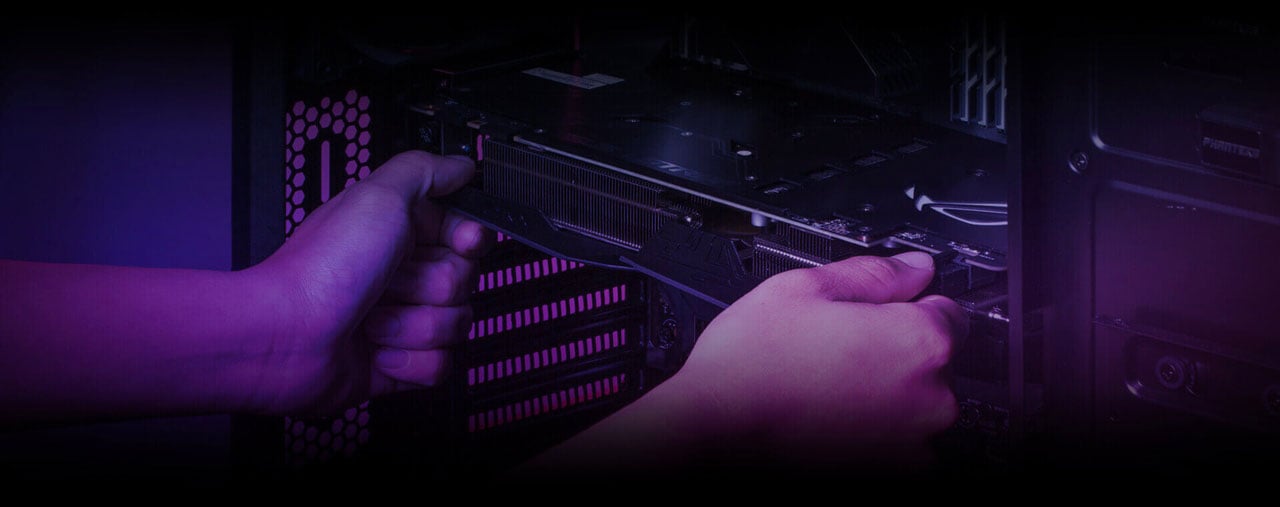  A graphics card held horizontally by two hands, in front of a motherboard in a computer case 