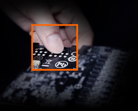 A hand holding the edge of the GIGABYTE graphics card PCB