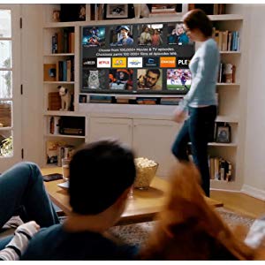 A family in their living room navigating the Roku menu on a RTRU5028-CA TV that's sitting on cabinet