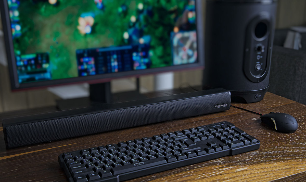 AverMedia Soundbar in Front of a Keyboard, Mouse, Subwoofer and Monitor on a Wooden Surface