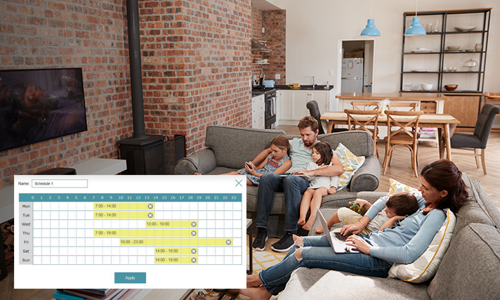 A family relaxing in their living room, the dad holds his two daughters using smart devices and the mother holds her son as she peruses a laptop