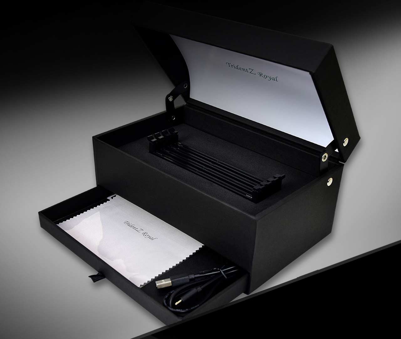 G.SKILL tridentz royal box angled to the left with its top half open and bottom compartment open showing a microfiber cleaning cloth and usb cable