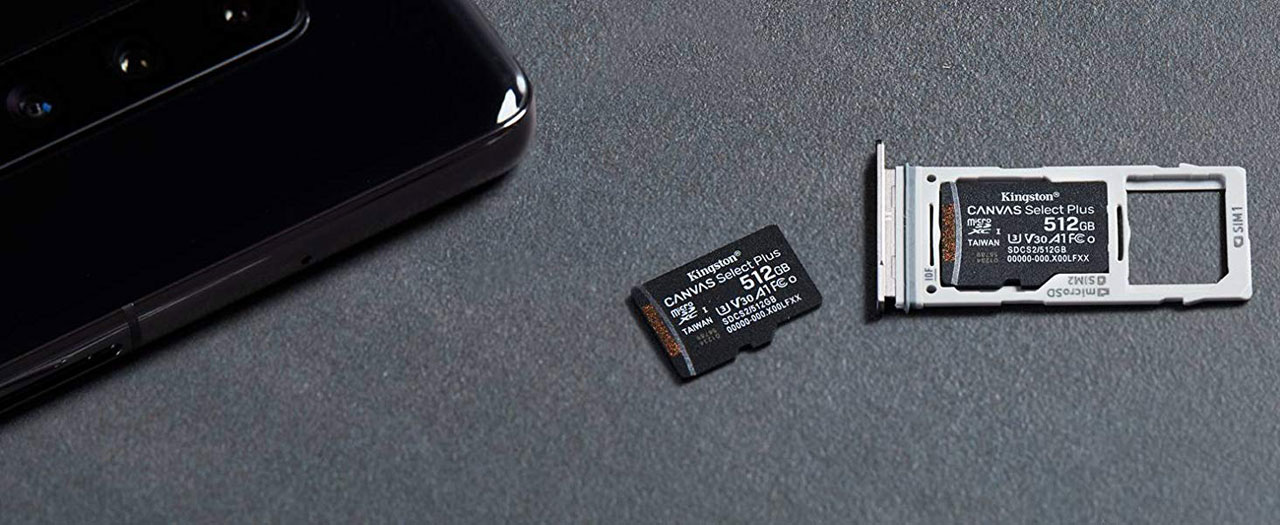  At the left is the rear of a mobile phone. Next to it on the right is a 512 GB card, and the phone’s SIM card tray with a 512 GB card on it  