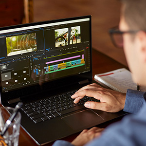 a man is working on video editing with his open laptop