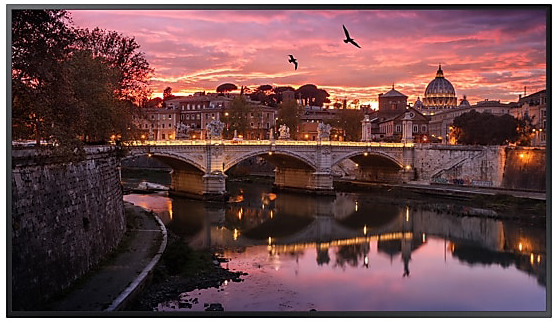 Samsung TV Facing Forward Showing a Bridge Over Water with a City at Twilight Hour and Birds Flying in the Sky