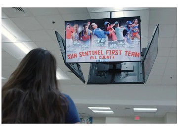 Four Mounted SAMSUNG QB75R-N Display on a ceiling that a woman is viewing from ground level