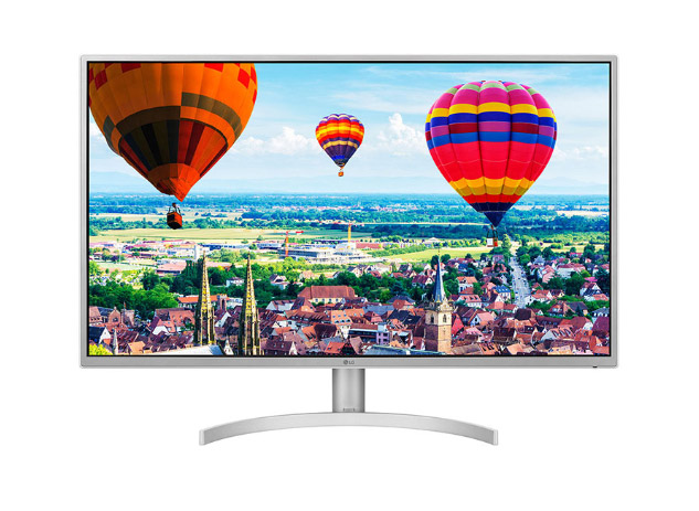 The LG 32QK500-W Monitor facing forward showing air balloons over a rustic town during the day