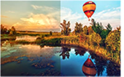 Hot air balloon flying over a forest-side lake 