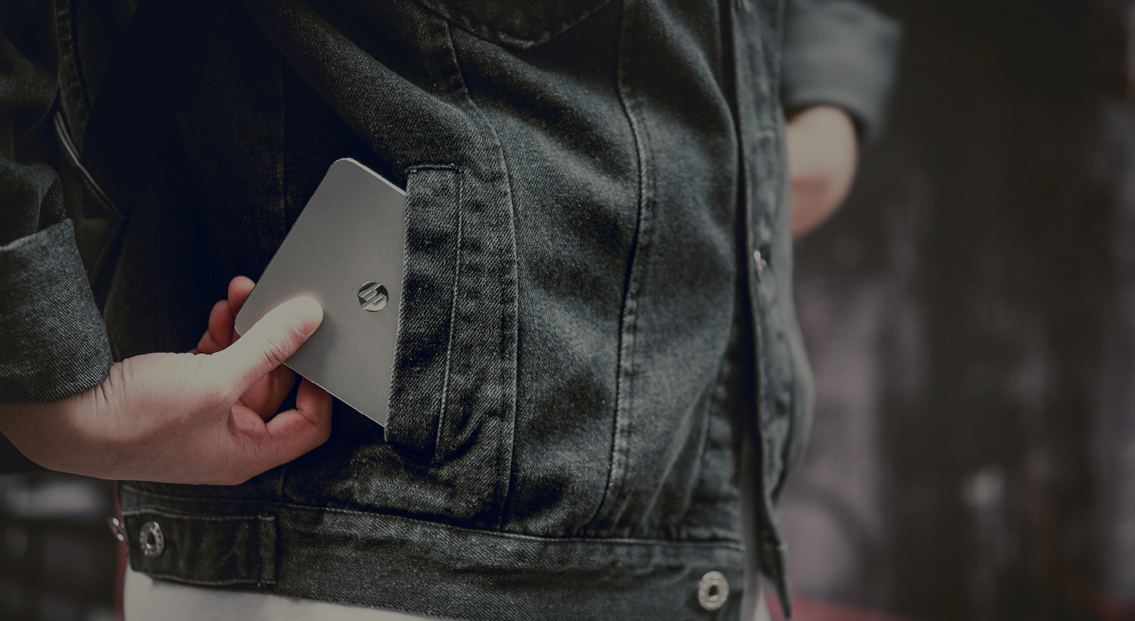 A Person Pulling out the HP MP100 from their Jean Jacket Pocket