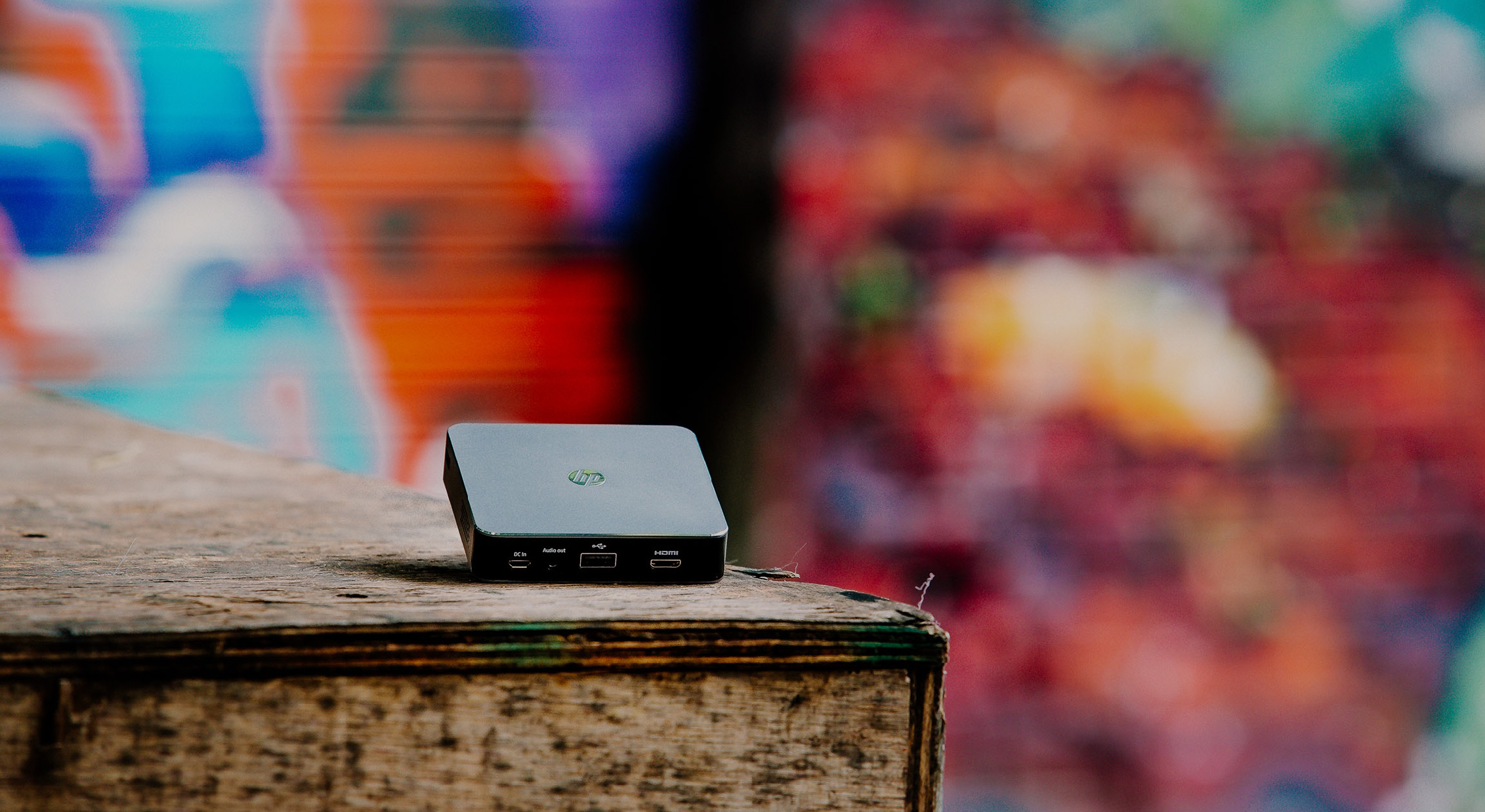 HP MP100 Projector Leaning Up on a Wooden Shelf Next to Graffiti Walls