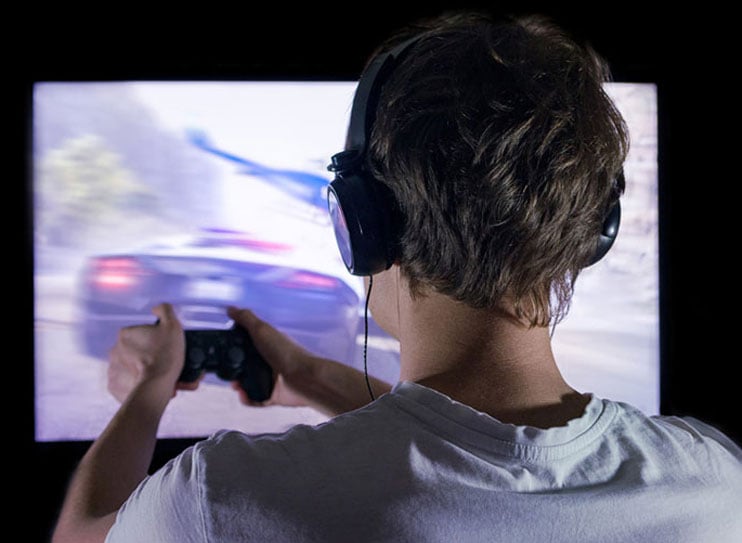 a man is playing console gaming in front of the monitor