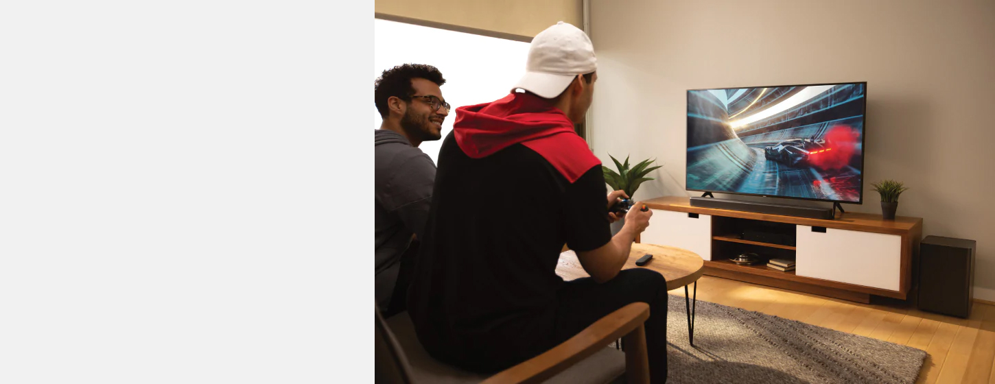 Two boys are playing games with JBL Bar 2.1 Deep Bass Soundbar connected to the TV
