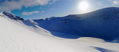 The sun above snow covered moutains