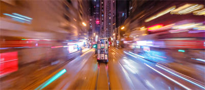A public transport trolley zooming through nighttime lights in a city