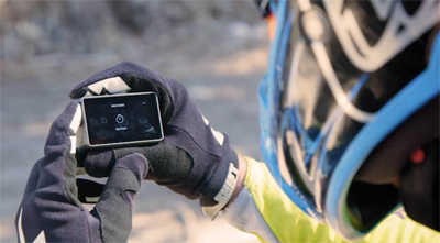 A Dirt Biker Taking a Break to Work with the Osmo Action in his gloved hands