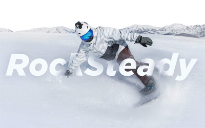 A snowboarder wearing a helmet that has the Osmo Action attached it, boarding through snow and text that reads: RockSteady