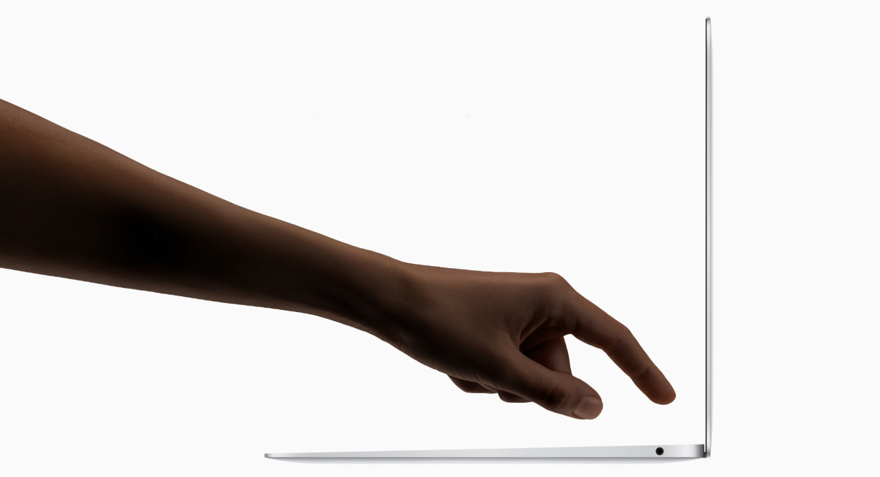 a hand is about to press the Touch ID on MacBook Air