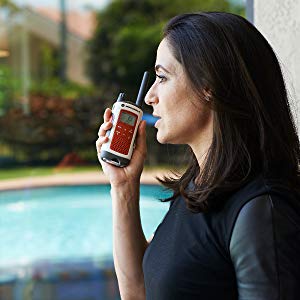 A female near a pool talking to the T480, held in her right hand   