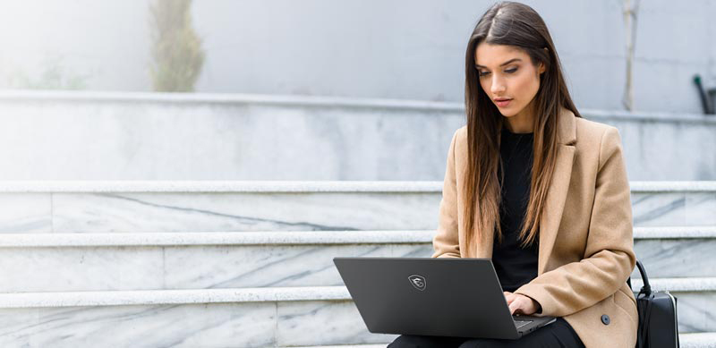 A Woman Is Using Notebook Outside.