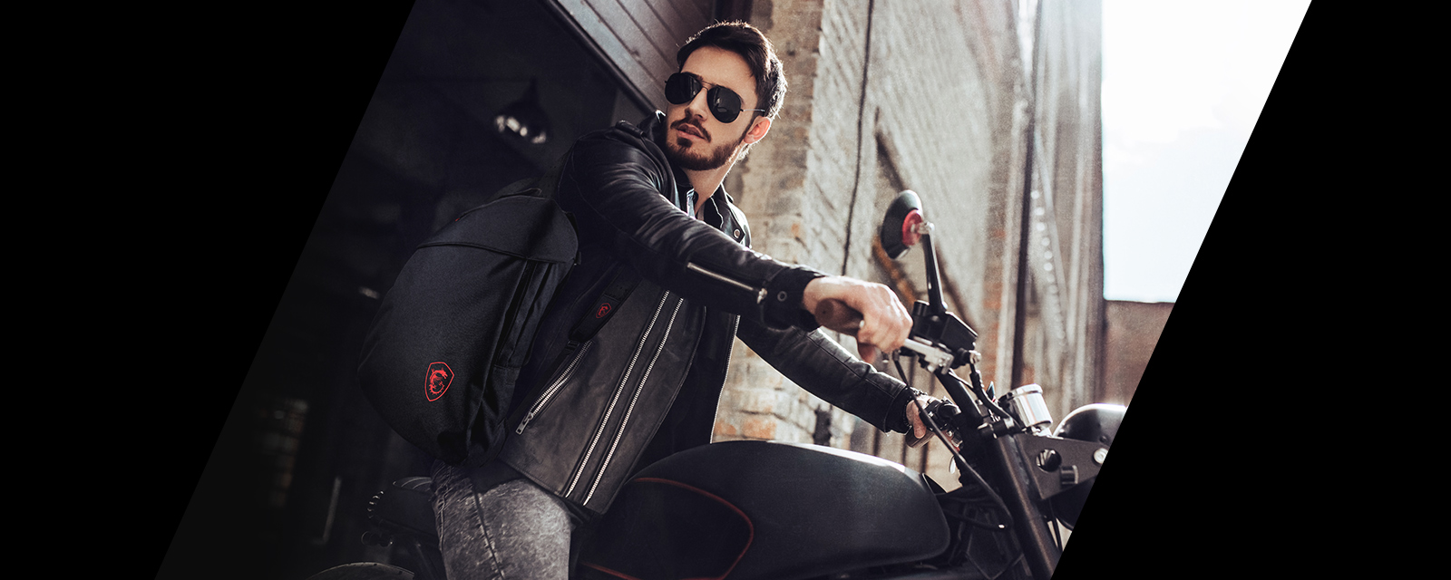 A man riding motorcycle carries notebook backpack .