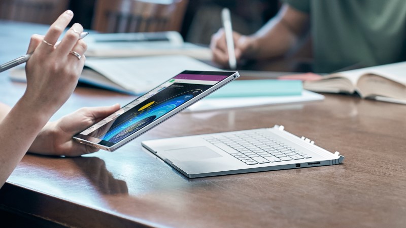 a person taking notes on the display of Surface Book