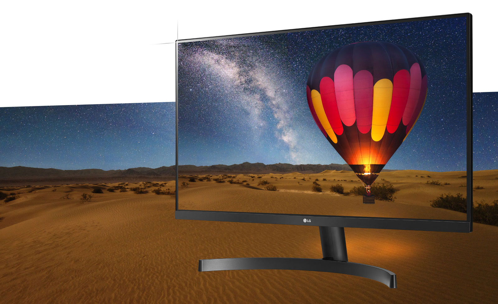 LG 22MK600M-B monitor angled to the left with its screen blending in with a hot-air balloon flying over a desert at night