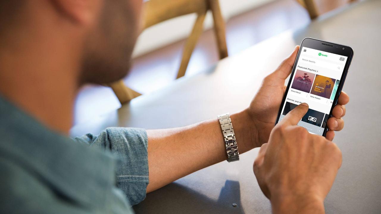 A man navigating his music app on his smartphone